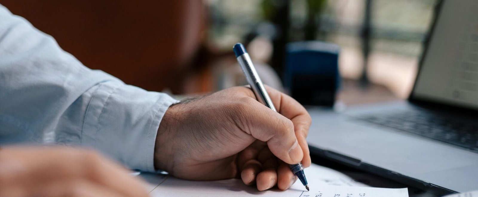Empresario escribiendo con boli en documento